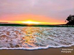 Sunset reflecting off the water through the green water wave