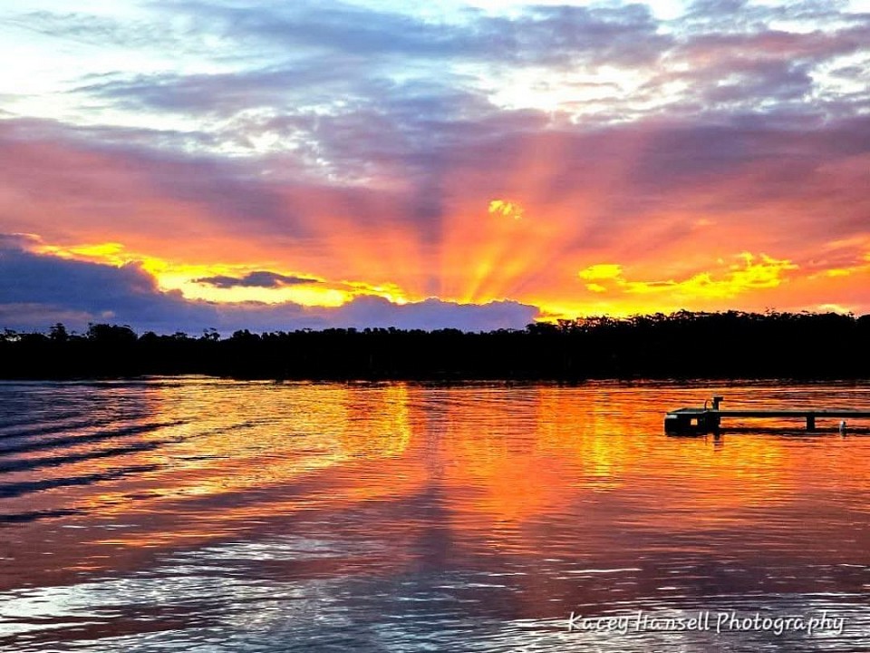 end of the jetty watching as the sun begins to set